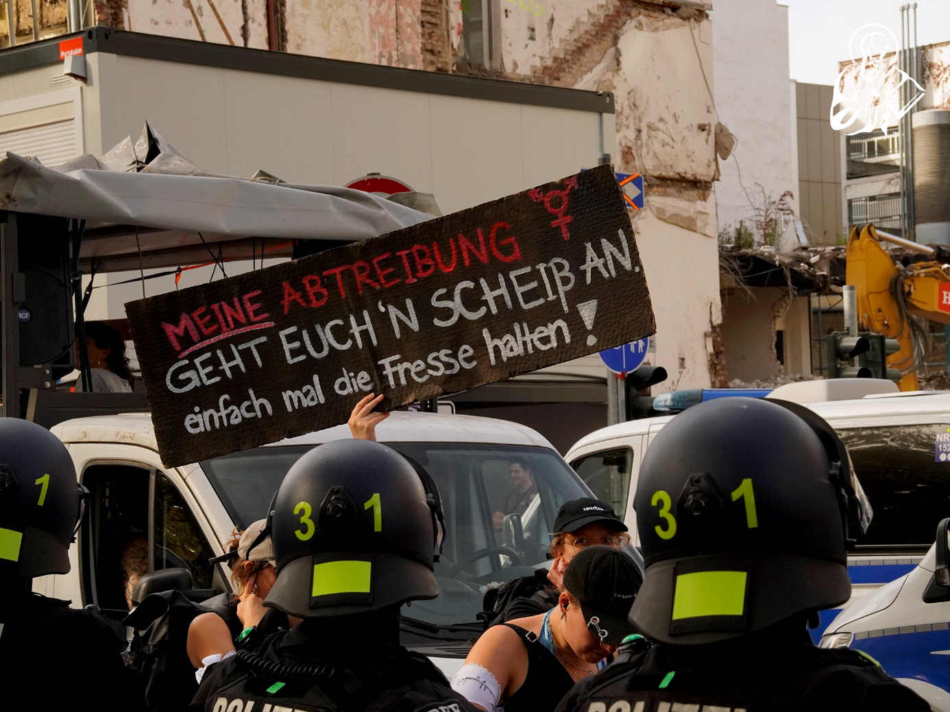 Ein Protestplakat hinter einer Polizeikette am Rande des K&ouml;lner Marsches f&uuml;r das Leben.